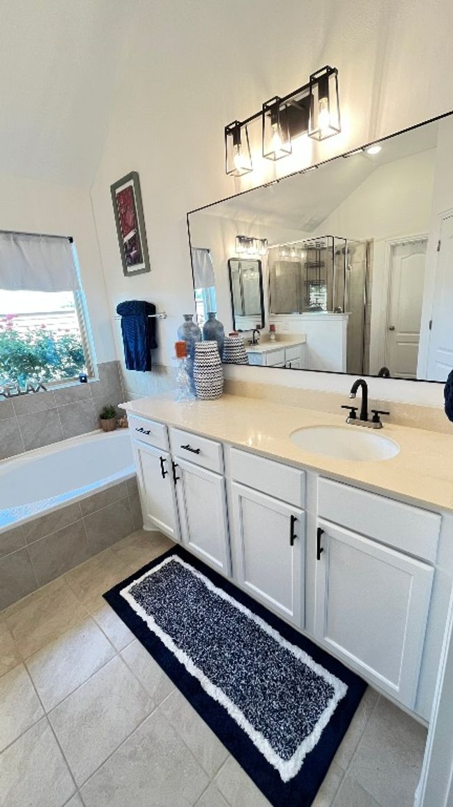 Bathroom featuring vanity, lofted ceiling, a garden tub, tile patterned flooring, and a shower stall | Image 21