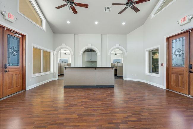 Unfurnished living room featuring high vaulted ceiling, ceiling fan, and visible vents | Image 8