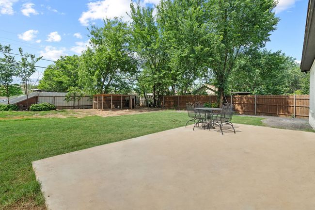 Fenced backyard with a patio area | Image 32