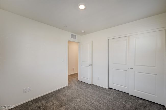 Unfurnished bedroom with dark carpet and a closet | Image 21
