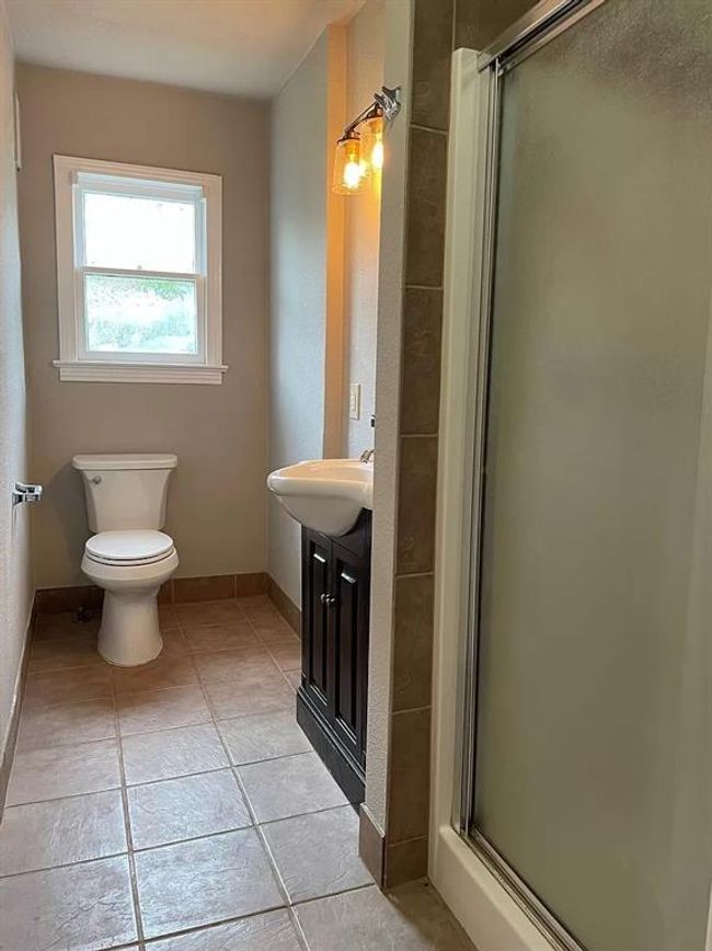 Full bathroom with tile patterned flooring, a stall shower, and vanity | Image 4