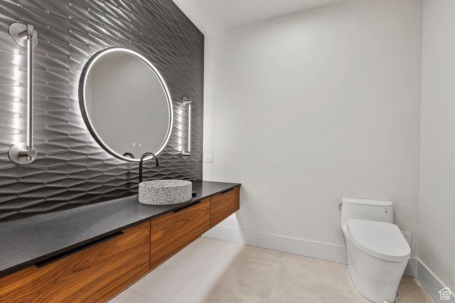 Bathroom featuring toilet, tile patterned floors, decorative backsplash, vanity, and baseboards | Image 41
