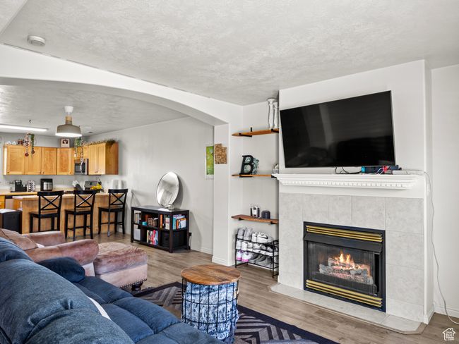 Living room featuring light hardwood / wood-style floors and a tile fireplace | Image 4