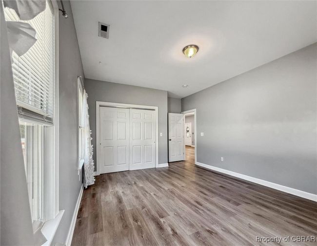 Unfurnished bedroom featuring wood finished floors, baseboards, and a closet | Image 21