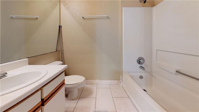 Full bathroom featuring toilet, washtub / shower combination, baseboards, and vanity | Image 5