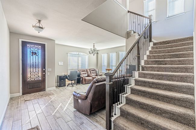Foyer with stairway, wood finish floors, baseboards, and a chandelier | Image 7