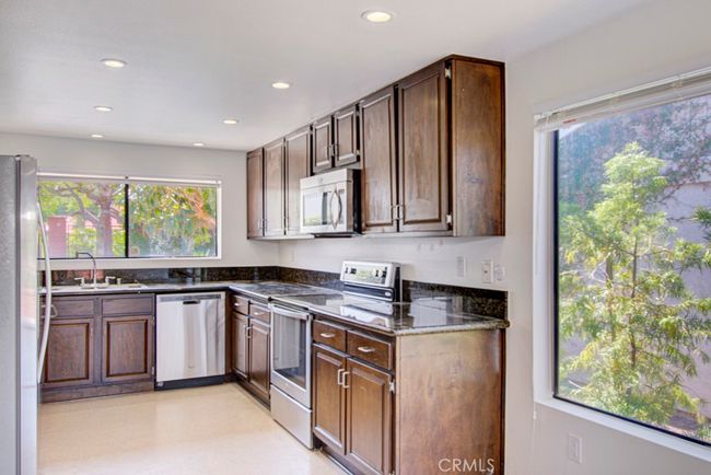 The kitchen has ample cabinet storage and stainless steel appliances. | Image 12