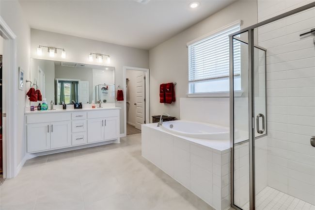 Full bathroom featuring double vanity, a shower stall, a garden tub, tile patterned floors, and recessed lighting | Image 23