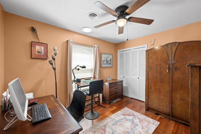 Office space with visible vents, wood finished floors, and ceiling fan | Image 21