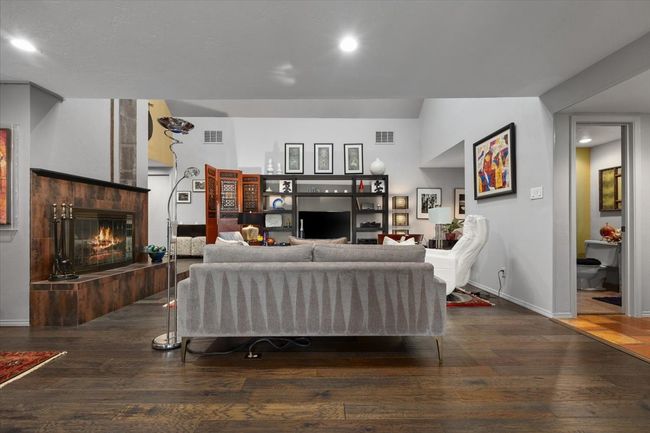 Living room with wood finished floors, a fireplace, vaulted ceilings. | Image 13