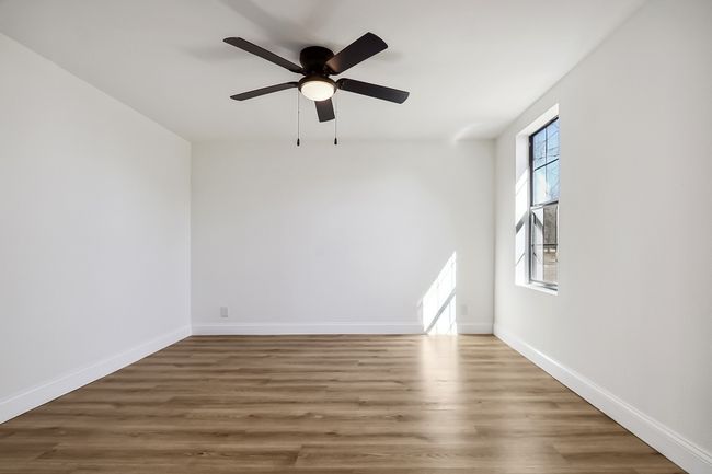 Unfurnished room featuring a ceiling fan, dark wood-style flooring, and baseboards | Image 13