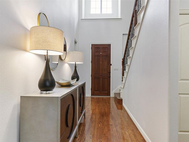 Foyer entrance featuring dark wood finished floors, stairway, and a towering ceiling | Image 4