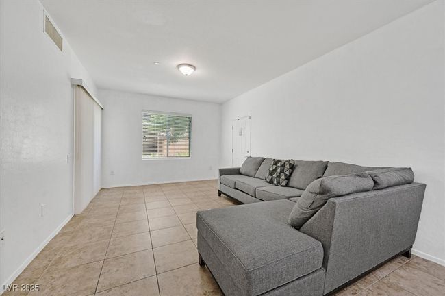 Living area with light tile patterned floors and baseboards | Image 5