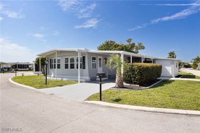 Manufactured / mobile home with a front yard and a garage | Image 1