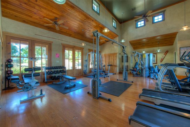A spacious, well-lit community fitness center equipped with a variety of workout machines, free weights, and exercise stations. T | Image 39