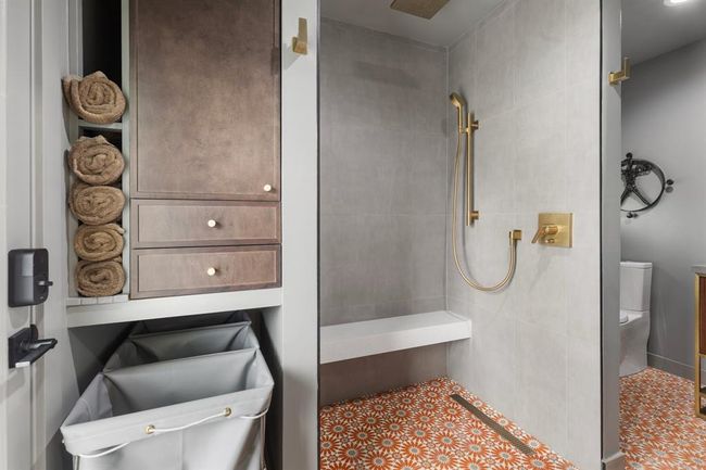 The luxurious primary bath features a spacious shower with modern finishes and fixtures. | Image 10