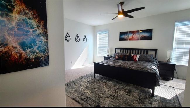 Bedroom featuring carpet, multiple windows, and ceiling fan | Image 18