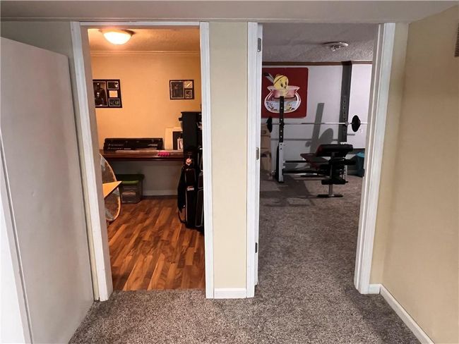 Hall featuring dark colored carpet and ornamental molding | Image 19