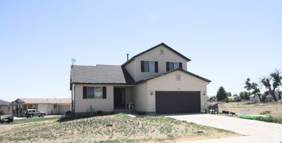 View of front facade featuring a garage and a front lawn | Image 1