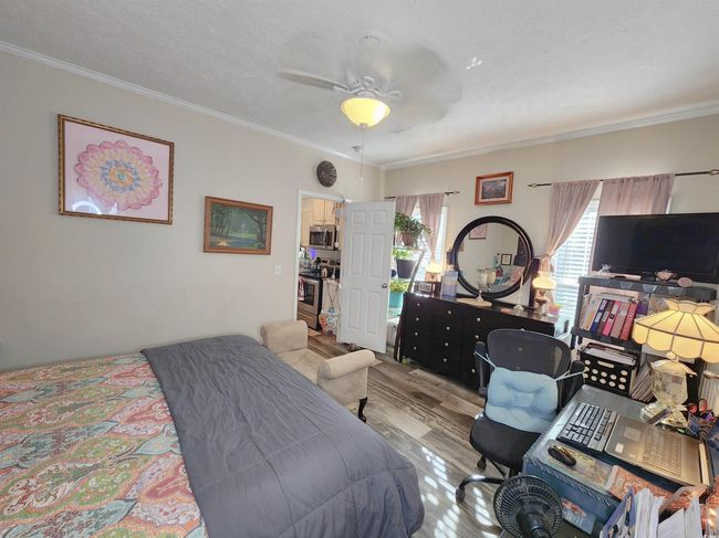 Bedroom with light hardwood / wood-style floors, ceiling fan, and ornamental molding | Image 15