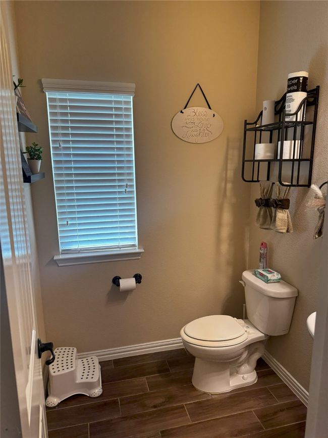 Half Bathroom with toilet and wood finish floors | Image 17
