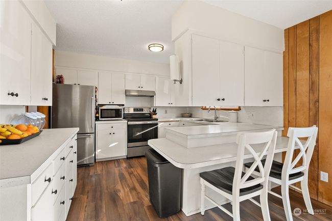 The kitchen truly serves as the heart of this home, combining warmth and functionality. With updated lighting and crisp white cabinets, the space feels light, bright, and inviting—making it the perfect setting for preparing meals or entertaining or simply enjoying a meal | Image 7