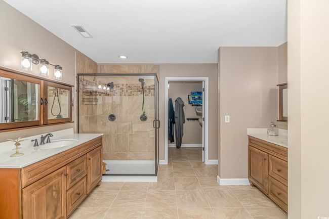 Bathroom with two vanities, a stall shower, and a walk in closet | Image 25