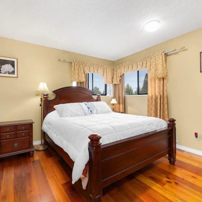 Bedroom with dark wood-type flooring and baseboards | Image 5