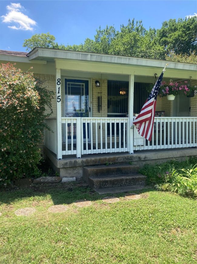 Doorway to property featuring a porch and a yard key box is on this door | Image 18