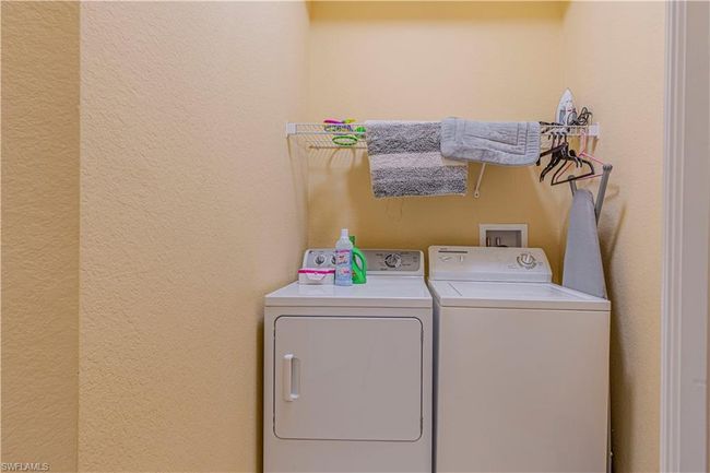 Laundry area with laundry area, separate washer and dryer, and a textured wall | Image 24