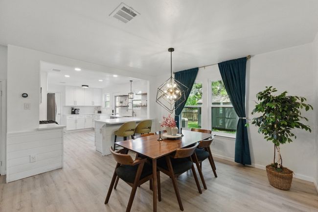 A modern light fixture in the dining area creates a stylish focal point and adds a touch of elegance. | Image 6