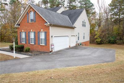 View of side of home with a deck and a yard | Image 3