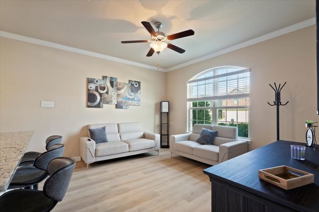 Home office featuring light wood-style floors, a ceiling fan, ornamental molding, and baseboards | Image 28