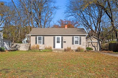 View of front of house featuring an outbuilding, a front lawn, and a garage | Image 1