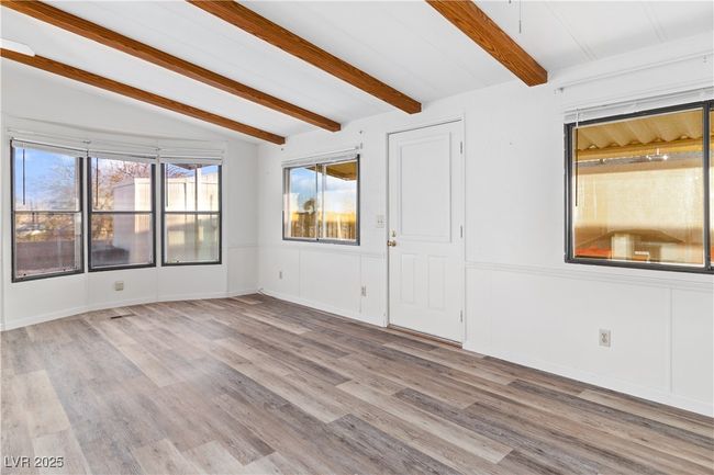 Living room featuring lofted ceiling with beams and wood style floors | Image 6