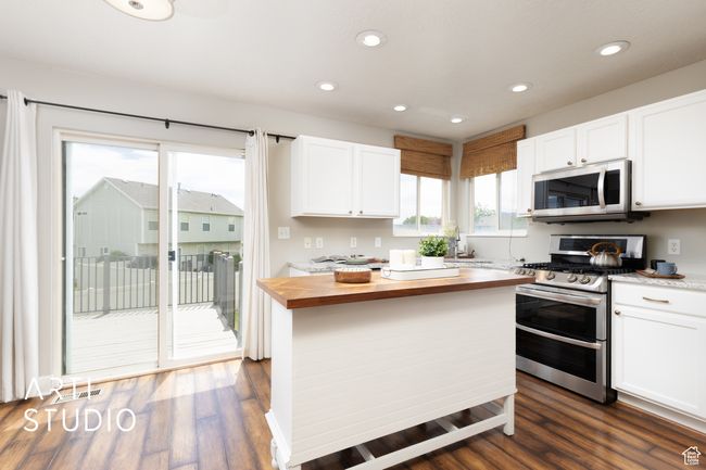 Kitchen featuring appliances with stainless steel finishes, wooden counters, white cabinets, recessed lighting, and dark wood-style floors | Image 7