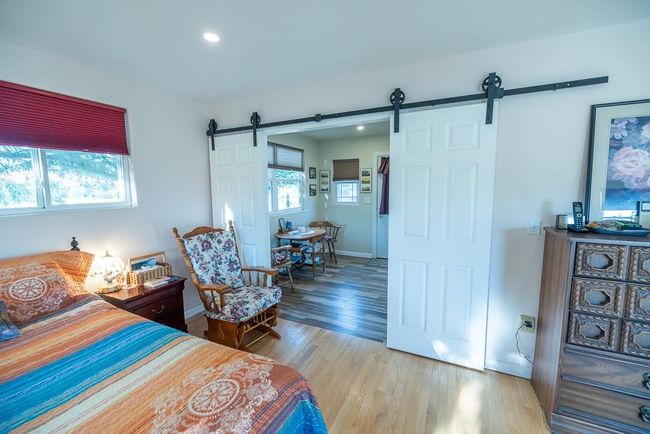 Bedroom with wood-type flooring and a barn door | Image 12