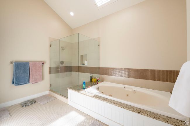 Bathroom with a tub with jets, a stall shower, and lofted ceiling | Image 28