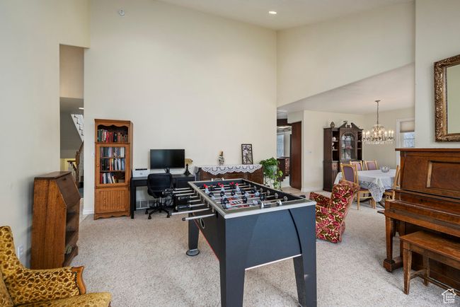 Game room with carpet floors, baseboards, a chandelier, and a towering ceiling | Image 12