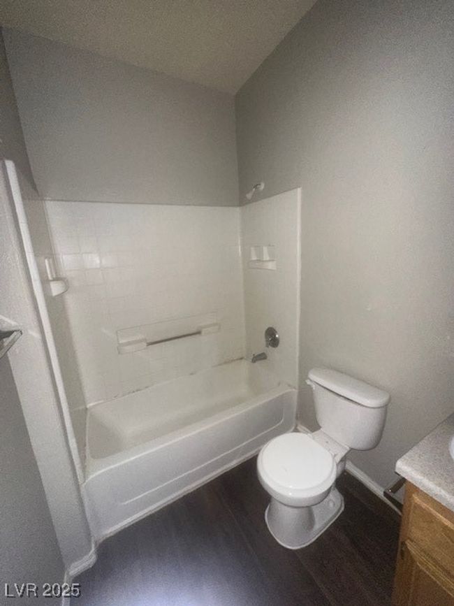 Bathroom featuring vanity, toilet, wood finished floors, shower / tub combination, and baseboards | Image 10