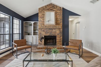 Living room with wood burning fireplace, and vaulted ceiling | Image 2