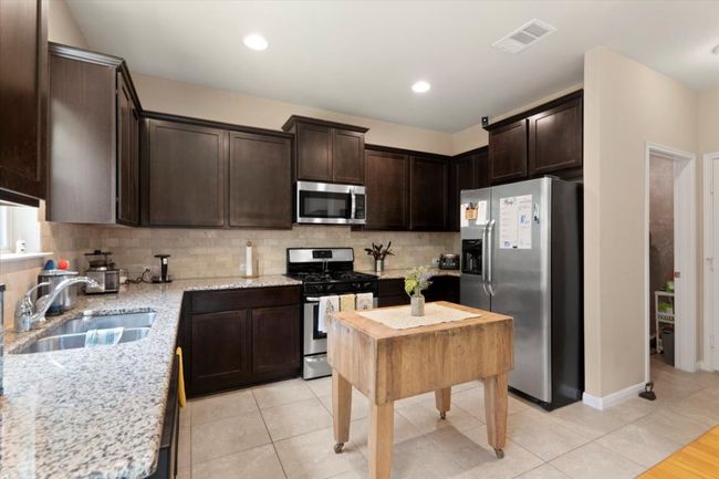 Open concept kitchen with stainless steel appliances. | Image 4