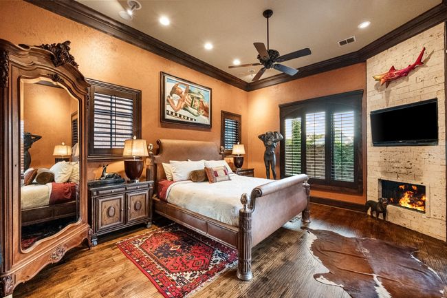 Bedroom featuring crown molding, wood floors, a fireplace, ceiling fan, and recessed lighting | Image 22