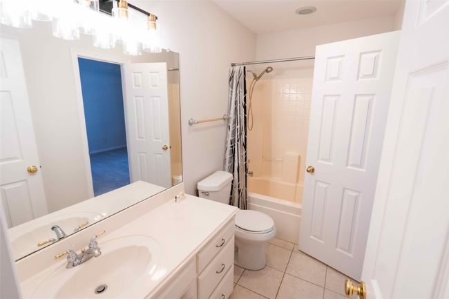 Bathroom with vanity, shower / tub combo, and tile patterned flooring | Image 23