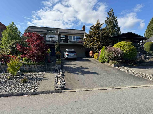 View of front of house with an attached garage, aphalt driveway, a balcony, and a chimney | Image 5