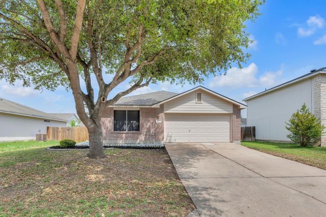 Ranch-style home with driveway, brick siding, a garage, and fence | Image 21