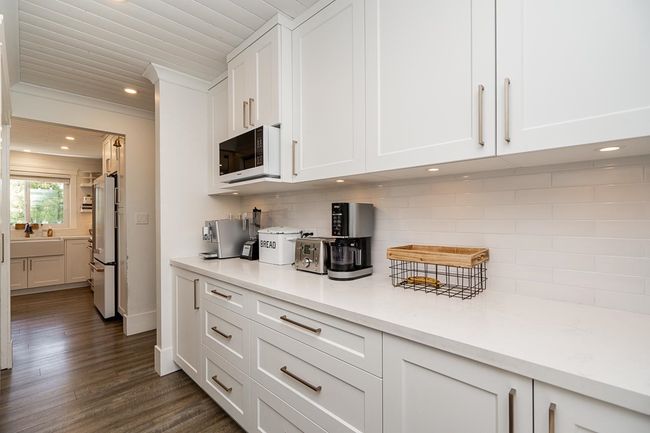 Kitchen featuring white cabinetry, recessed lighting, white appliances, and decorative backsplash | Image 9