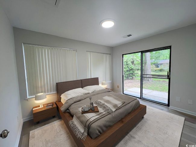 Bedroom with wood finished floors, baseboards, visible vents, and access to exterior | Image 37