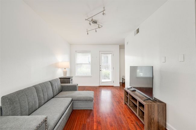 Living room with dark wood-style flooring, baseboards, and rail lighting | Image 13