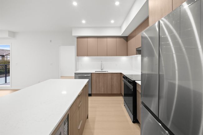 Kitchen with stainless steel appliances, modern cabinets, light wood-style floors, light countertops, and recessed lighting | Image 4